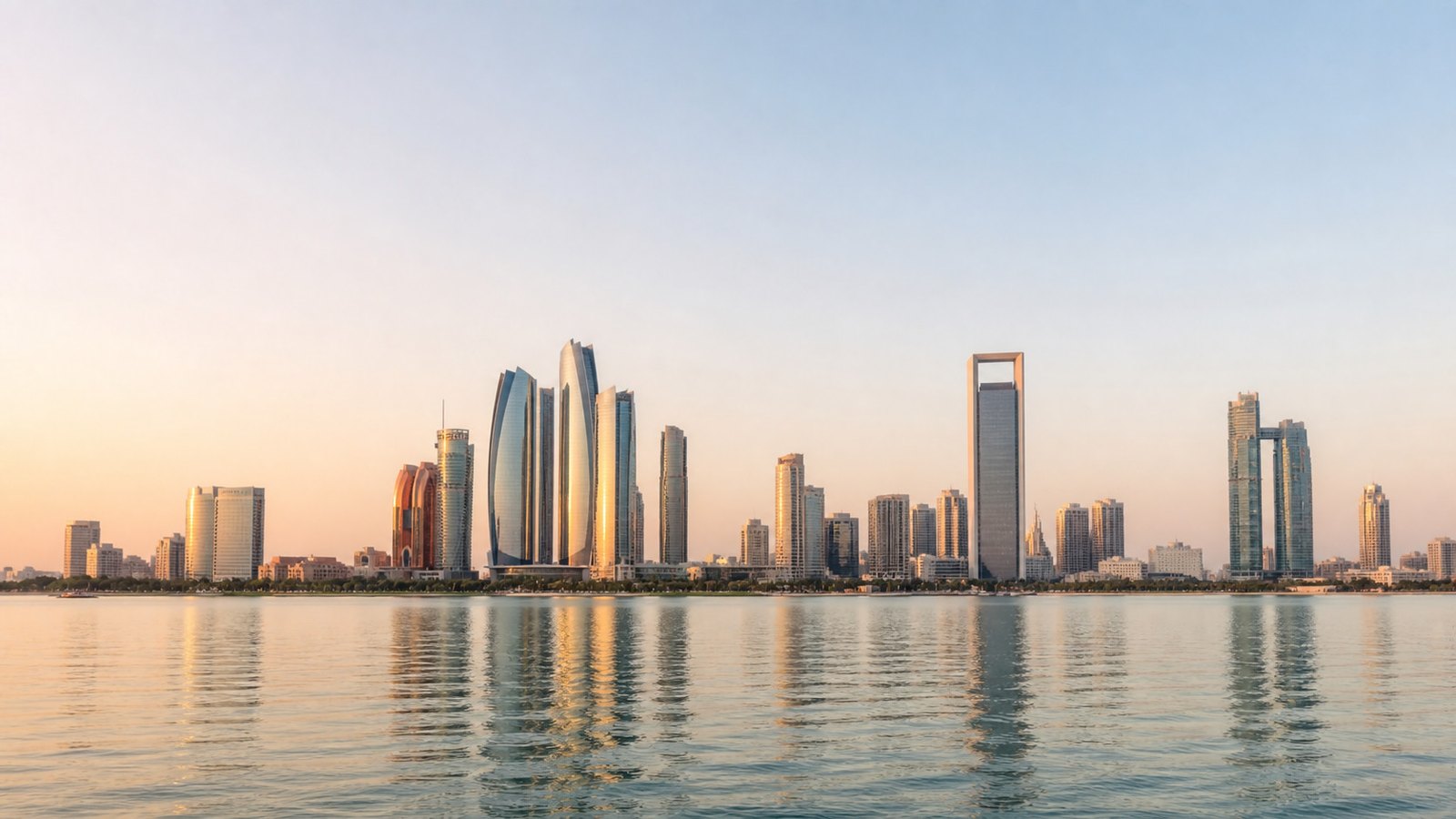 The Abu Dhabi skyline at first light, reflected in calm water