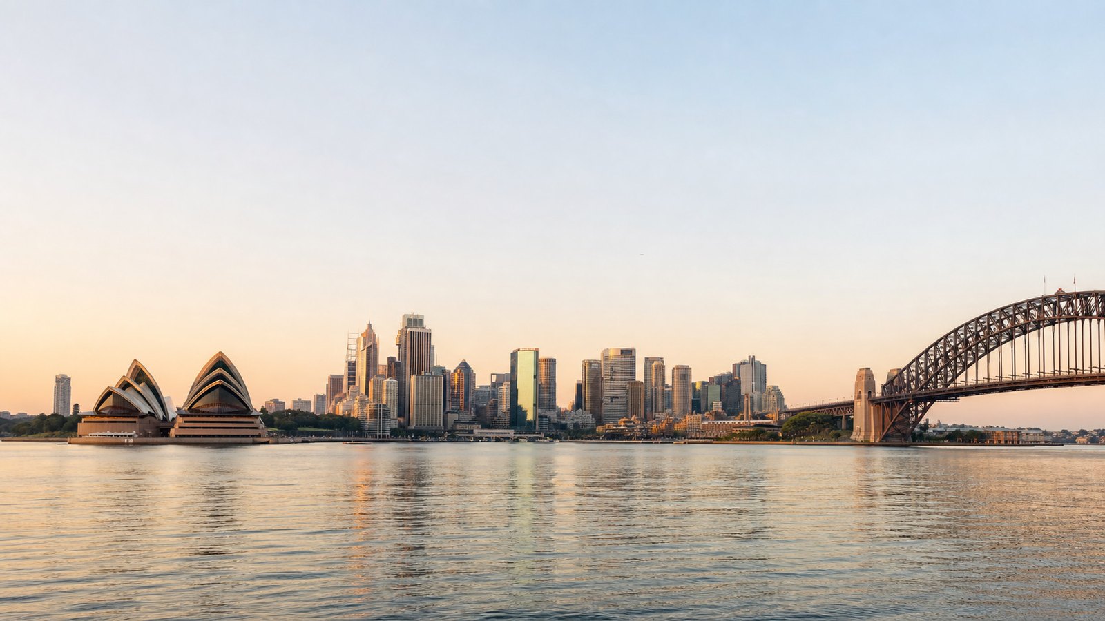 The Sydney skyline at dawn, Opera House and Harbour Bridge across the water